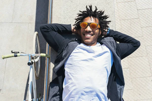 Knappe afro man ontspannen in de buurt van zijn fiets. — Stockfoto