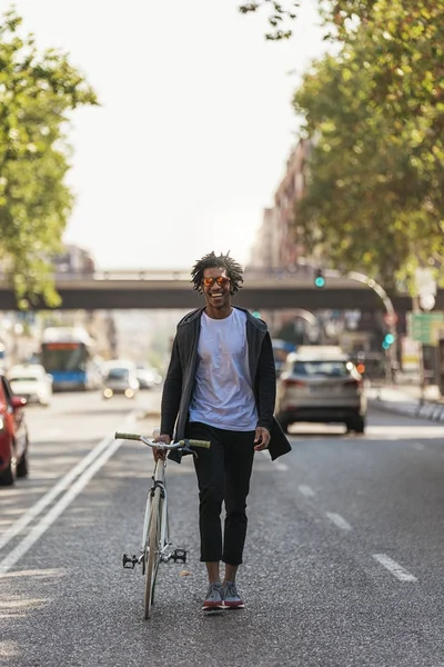Όμορφος άνδρας Αφρο περπάτημα με το ποδήλατό. — Φωτογραφία Αρχείου