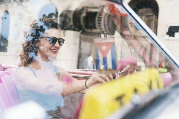 Bella donna turista alla guida di una macchina d'epoca a Cuba . — Foto Stock