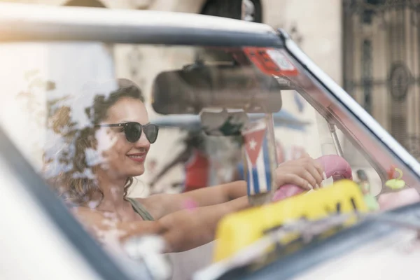 Hermosa turista conduciendo un coche clásico en Cuba . — Foto de Stock