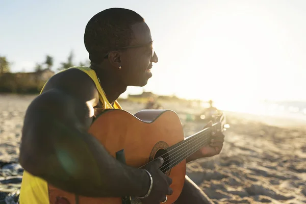 Ung kubansk man har kul på stranden med sin gitarr. — Stockfoto