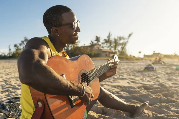 Młody człowiek kubański, zabawy na plaży z gitarą. — Zdjęcie stockowe