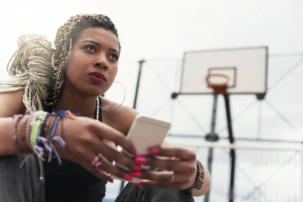 Porträt einer schönen schwarzen Frau, die ihr Handy im Nachbarhaus benutzt — Stockfoto