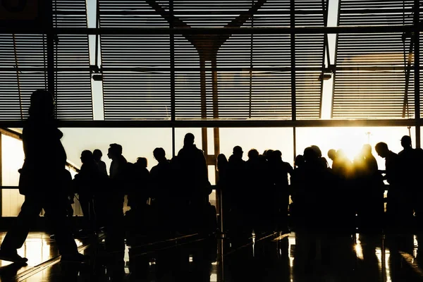 Silhouetten von Menschen, die am Flugsteig warten. — Stockfoto