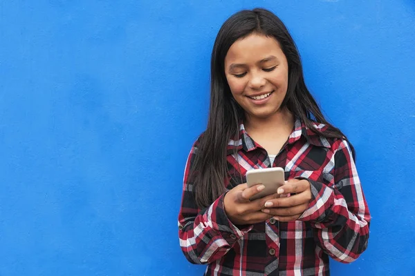 Retrato de una linda chica latina usando el móvil en la calle . — Foto de Stock