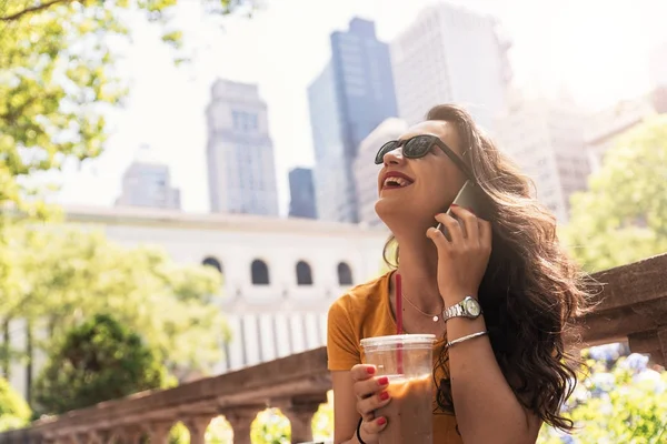 Beautiful woman using phone while drinking a coffee in New York. — Stock Photo, Image