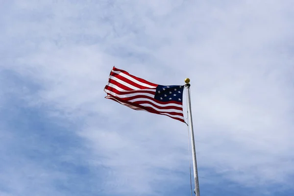 Amerikaanse vlag aan de blauwe hemel. — Stockfoto