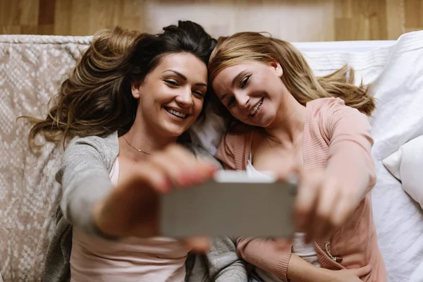 Wunderschöne Freunde machen ein Selfie im Schlafzimmer. — Stockfoto