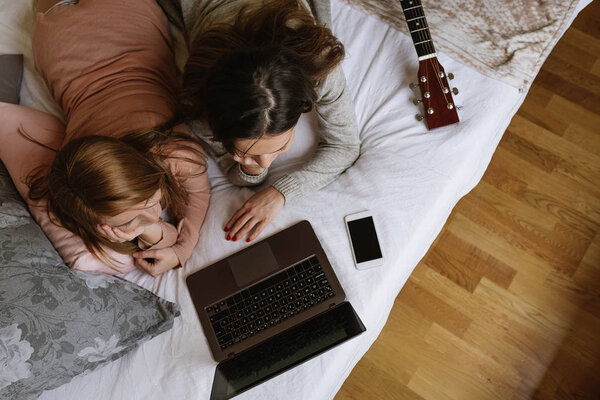 Gorgeous friends using the laptop in the bedroom. — Stock Photo, Image