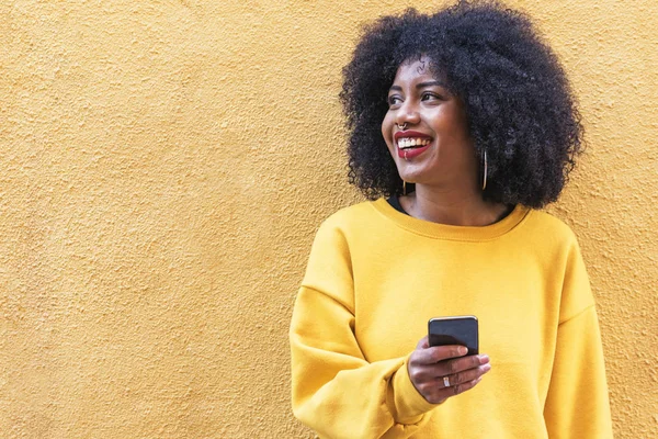 Bella donna afro americana che utilizza il cellulare in strada . — Foto Stock