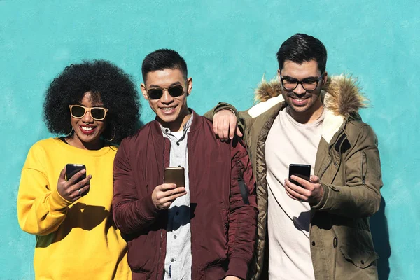 Grupo de amigos felices usando el móvil en la calle . — Foto de Stock