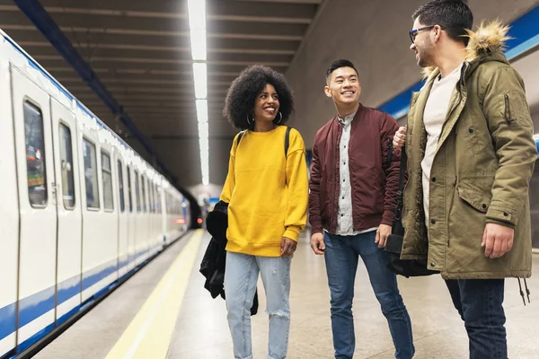 Grupo de amigos esperando el tren en la plataforma de la estación de metro . —  Fotos de Stock