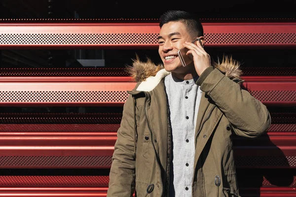 Pria asia yang tampan menggunakan ponsel di stasiun kereta api . — Stok Foto