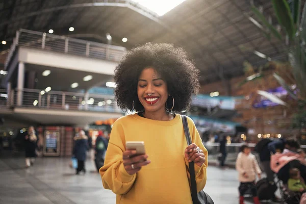 Mulher bonita usando móvel na estação de trem . — Fotografia de Stock