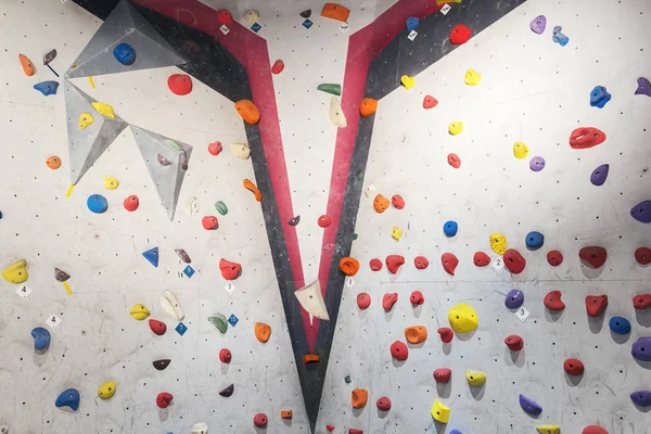 Mur gris avec des prises d'escalade et des cordes dans la salle de gym . — Photo