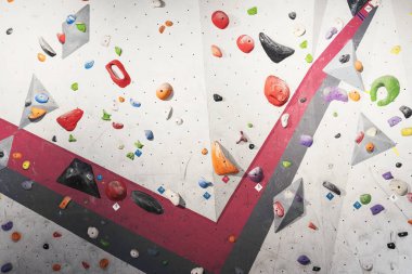 Gri duvar tırmanışı ile spor salonunda tutar.