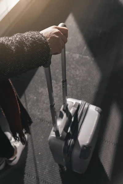 Nahaufnahme einer Frau mit einem Koffer im Flughafen. — Stockfoto
