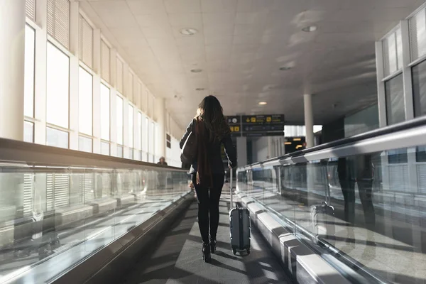 Nelze rozpoznat žena chůze s kufrem na letišti. — Stock fotografie