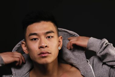 Genç Asyalı çocuk üstüne alarak.