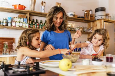Little sisters ile annesi mutfakta yemek.