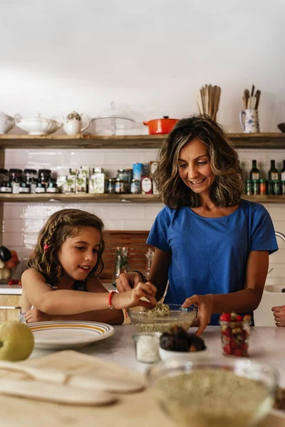 Niña cocinando con su madre en la cocina. — Foto de Stock