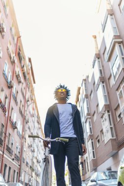 Cep telefonu ve sabit vites bisiklet kullanma yakışıklı genç.