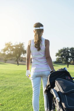 Genç ve güzel kadın golf oynamak.