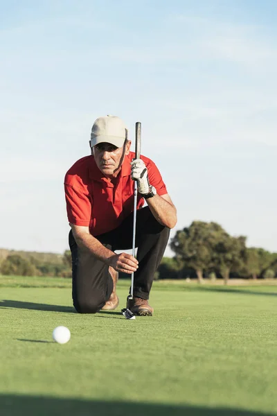 Jogador de golfe sênior concentrando para colocar em verde . — Fotografia de Stock