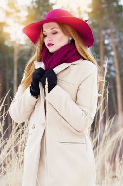 Palto ve şapka ormanda genç, güzel ve şık Kızıl saçlı kız. Moda.