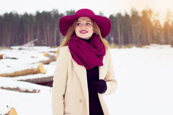Sorridente ragazza elegante, giovane e bella che indossa cappotto e cappello nella foresta. Moda . — Foto Stock