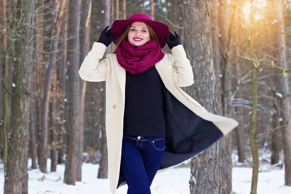 Молодая, красивая и стильная рыжеволосая девушка в пальто и шляпе гуляет по лесу. Мода . — стоковое фото