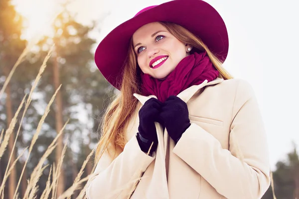 Стильная, молодая, красивая и улыбающаяся рыжеволосая девушка в пальто и шляпе в лесу. Мода . — стоковое фото