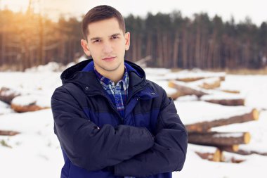 Ceket ayakta ormandaki yakışıklı, şık ve genç adam. Erken Bahar güneşli bir gün. Erkek moda.