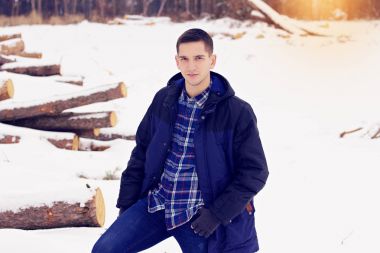 Ceket ayakta ormandaki yakışıklı, şık ve genç adam. Erken Bahar güneşli bir gün. Erkek moda.