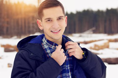 Yakışıklı, şık ve genç gülümseyen adam gömleğini düzeltmek ceketli. Erken Bahar güneşli bir gün. Erkek moda.