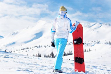 Karlı Dağları'nda snowboard ile baş onu ayakta üzerinde kayak pantolon ve googles mavi beyaz ceketli genç güzel kız. Kış sporları.