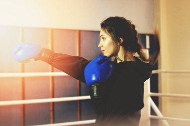 Güzel boks kız halka güçlü yumruk gerçekleştirir. Eğitim salonunda. Sportif erkek boks egzersiz yaparak.