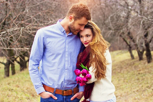 Glücklich zusammen. Porträt eines bärtigen Hipstermannes, der zusammen mit seiner schönen Freundin im Garten steht. schönes junges Paar. — Stockfoto