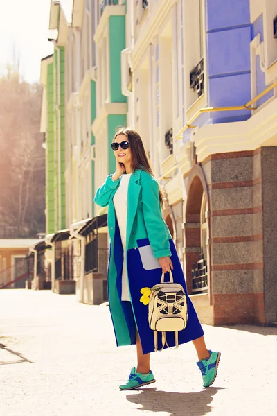 Έννοια μόδα του δρόμου. Μοντέρνα, νεαρή και όμορφη κοπέλα με μπλε παλτό και backack με τις τουλίπες το περπάτημα στην πόλη. — Φωτογραφία Αρχείου