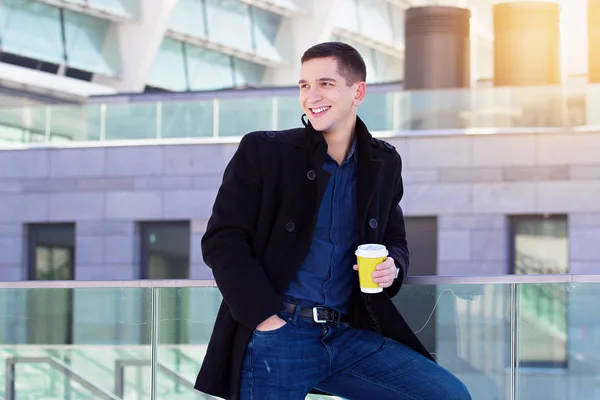 Boldog üzletember. Mosolygó üzleti fiatalember kávét iszik, miközben állandó szabadban közelében irodaház portréja. — Stock Fotó