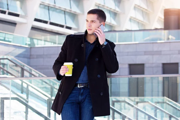 Üzleti beszélgetés. Beszél a telefon, miközben a kávéfogyasztás kívül irodaház, a magabiztos és sikeres üzletember portréja. — Stock Fotó