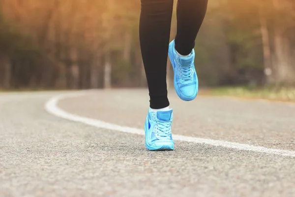 Zdravý životní styl a sport koncept. Detailní portrét běžících nohou sportovní dívky v parku silnici. Modré tenisky. — Stock fotografie