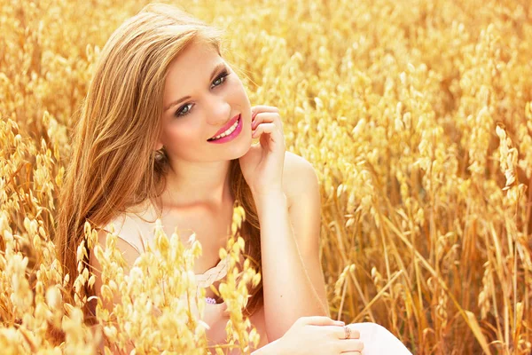 Чиста краса. Портрет молодої і привабливої усміхненої червоної волохатої дівчини, одягненої в біле плаття, що позує на жовтому пшеничному полі . — стокове фото