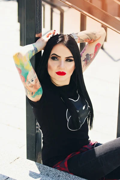 Módní tetování. Portrét módní hipster Tetovaný dívka s červenými rty vystupují proti městské pozadí. — Stock fotografie