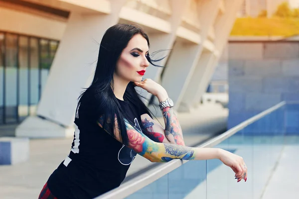 Татуйована краса. Портрет привабливої татуйованої хіпстерки, що стоїть на міському тлі . — стокове фото