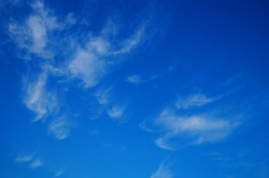 Güneşli bir yaz gününde, mavi doymuş gökyüzünde beyaz yumuşak bulutlar.