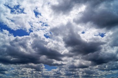 Güneşli bir yaz gününde, mavi doymuş gökyüzünde beyaz yumuşak bulutlar.