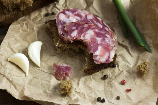 Bitten black bread with chopped sausage