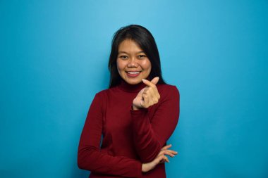 Mavi izole edilmiş geçmişi olan güzel Asyalı kadınların portresi, parmaklarınla seviş.