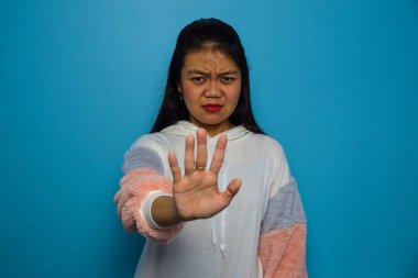 Mavi izole edilmiş arka planı olan güzel Asyalı kadın portresi, avucunun içi gibi şarkı söylemeyi kesiyor.